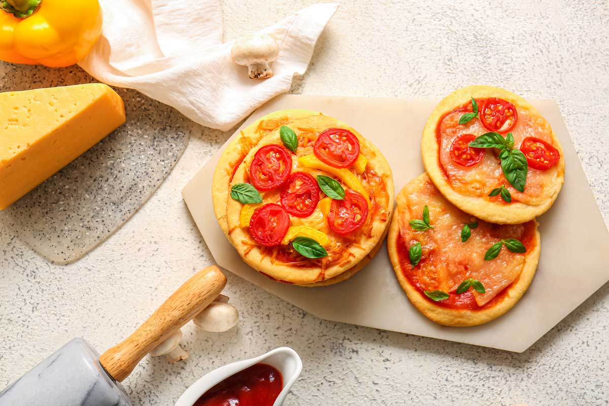 Mini pizzy z nekynutého těsta s rajčaty, sýrem a bazalkou