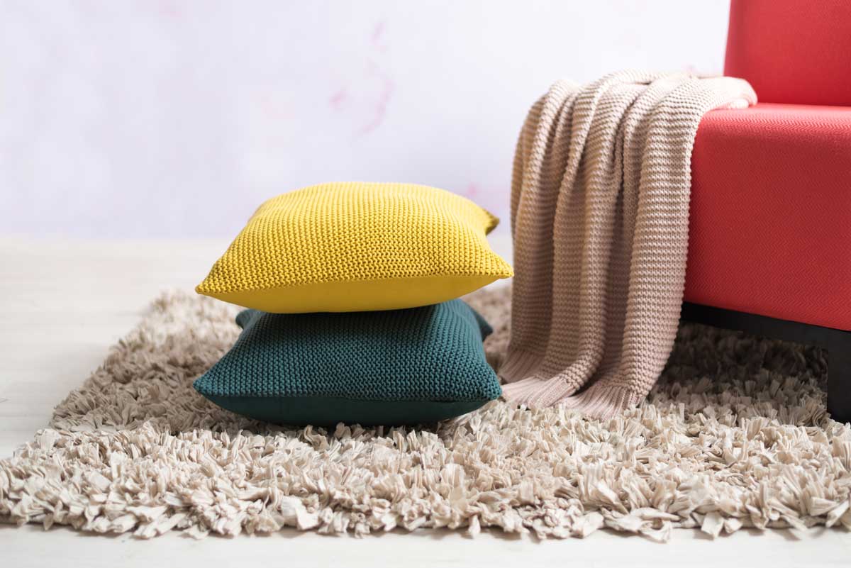 hunaty koberec Huňatý koberec s dekoračními polštáři a dekou v interiéru.