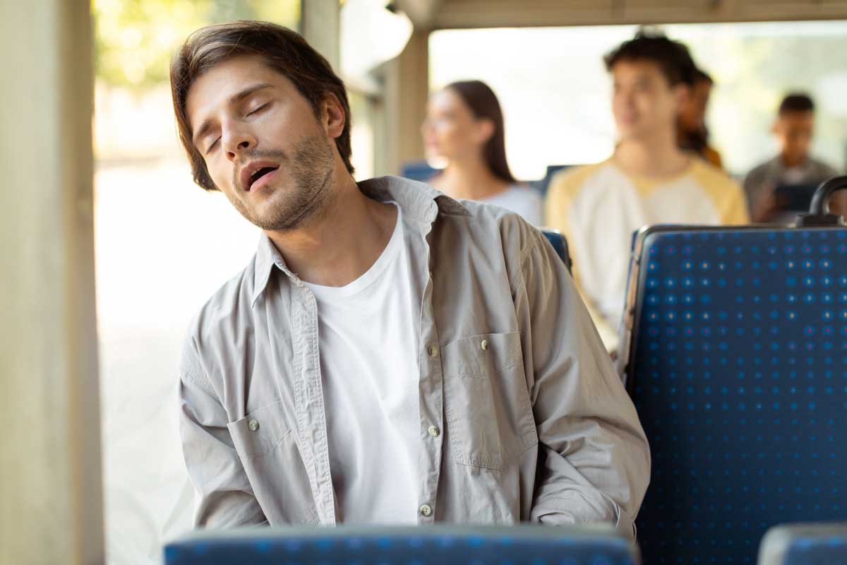 Unavený muž usíná během dne v autobuse jako důsledek nedostatku spánku