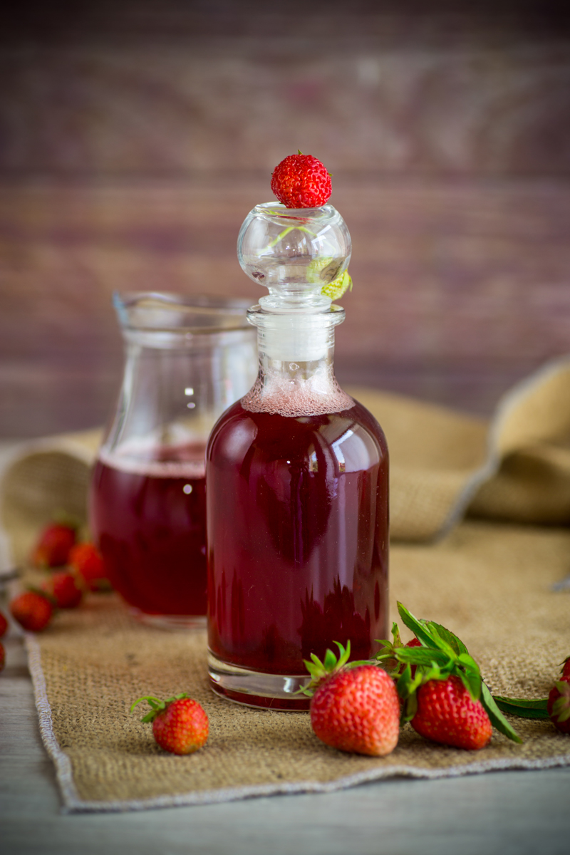 jahodovy sirup Domácí jahodový sirup ve skleněné lahvi připravený z čerstvých jahod.