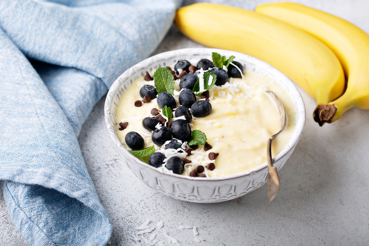 Banánová nice cream je ozdobená borůvkami, kokosem a čokoládovými pecičkami.