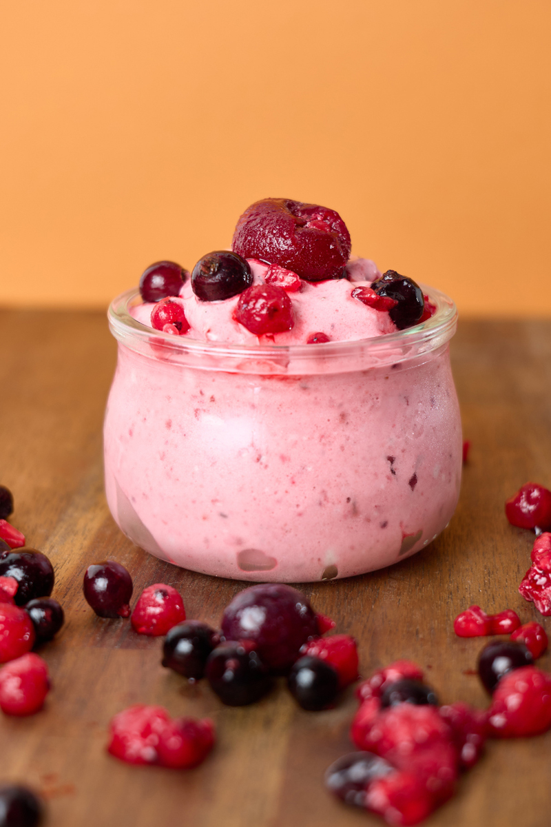 Nice cream z lesního ovoce má svěží růžovou barvu a je ozdobená mraženým ovocem.