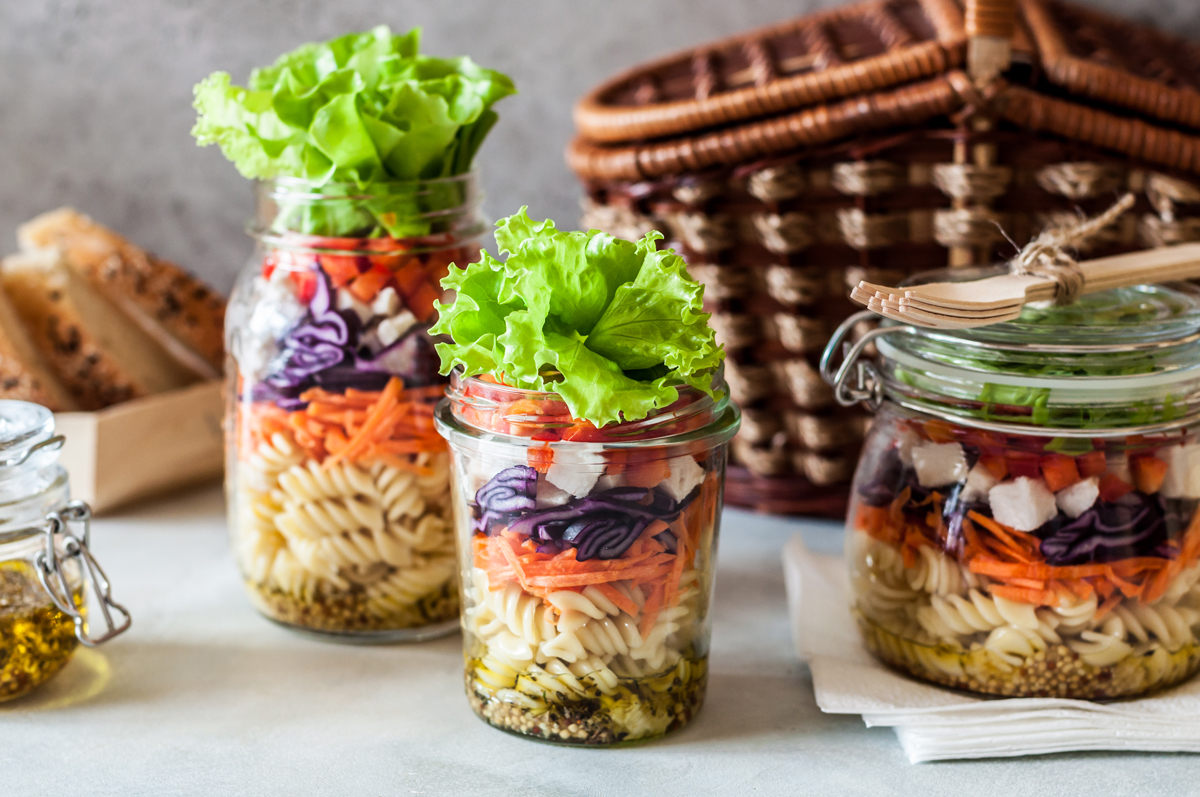 testovinovy salat Těstovinové saláty ve sklenicích s dresinkem, těstovinami, zeleninou a listovým salátem připravené na cesty nebo do práce.