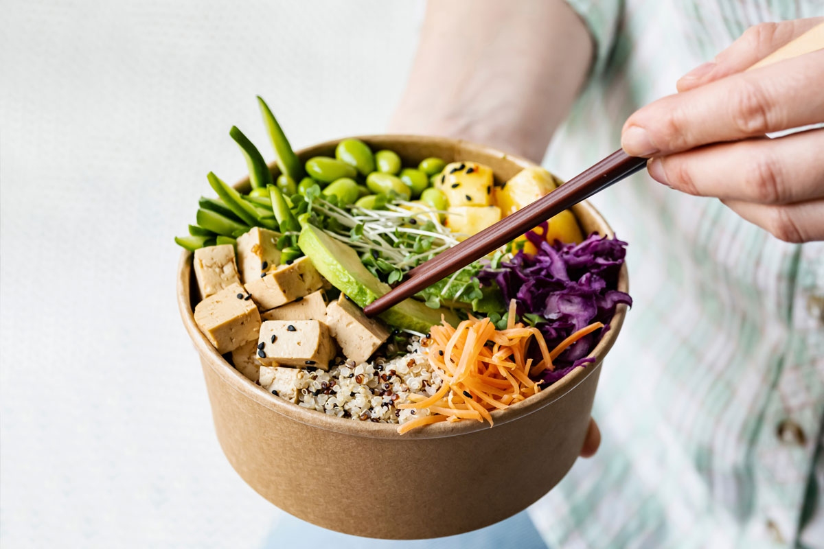 veganska Vegetariánská poke bowl s barevnou zeleninou, avokádem a edamame.