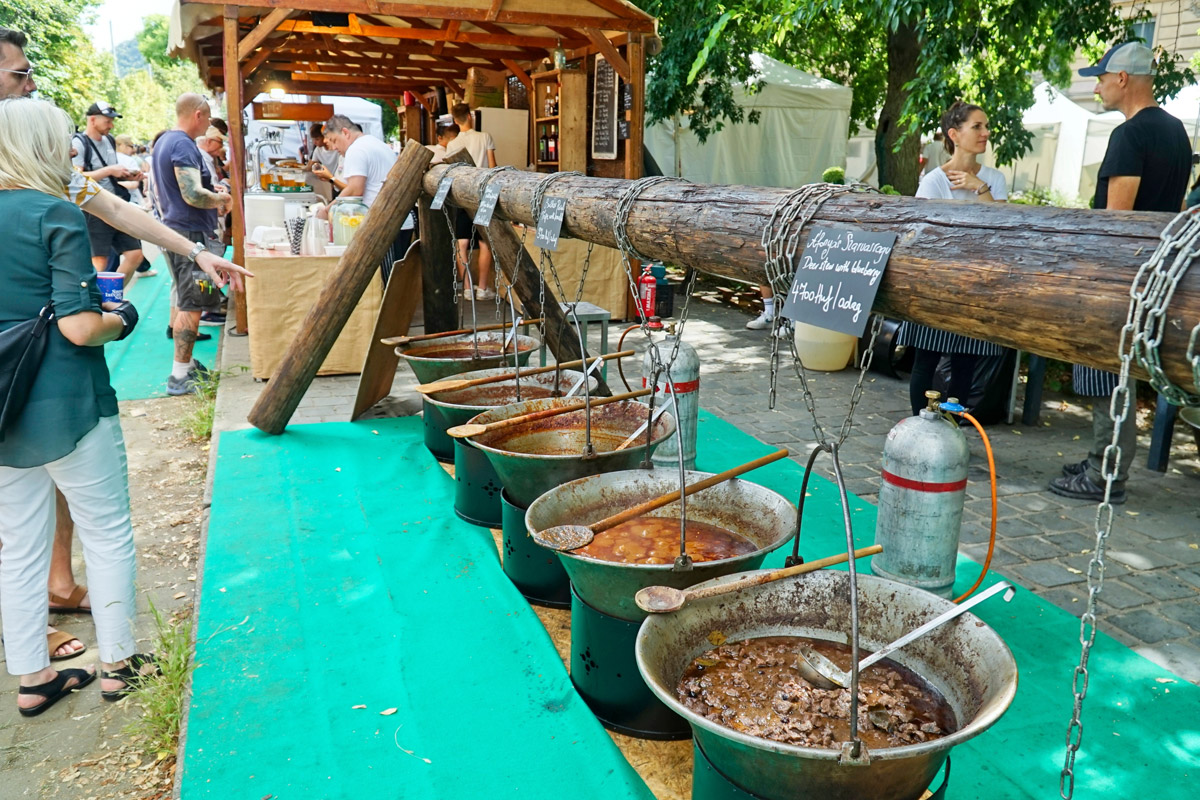 gulasfest Návštěvníci ochutnávají různé druhy gulášů připravovaných ve velkých kotlích během tradičního gulášového festivalu.