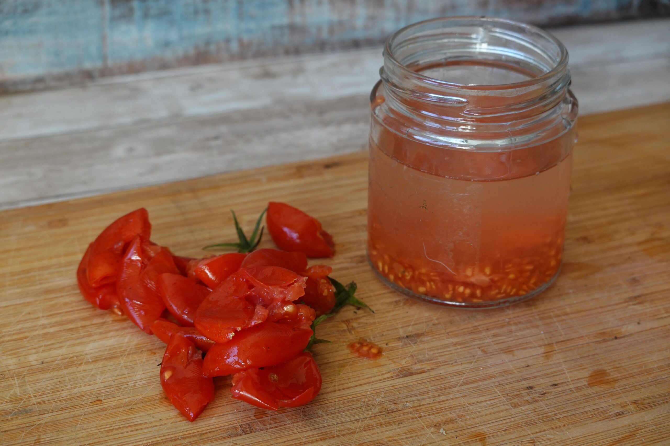fermentovani rajcatovych semen Semena rajčat s dužinou namočená ve sklenici s vodou před fermentací.