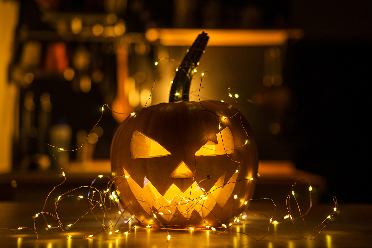 LED svetylka do dyne 1 Vyřezaná halloweenská dýně se svítícím strašidelným obličejem ozdobená drobnými LED světýlky s teplým žlutým světlem.